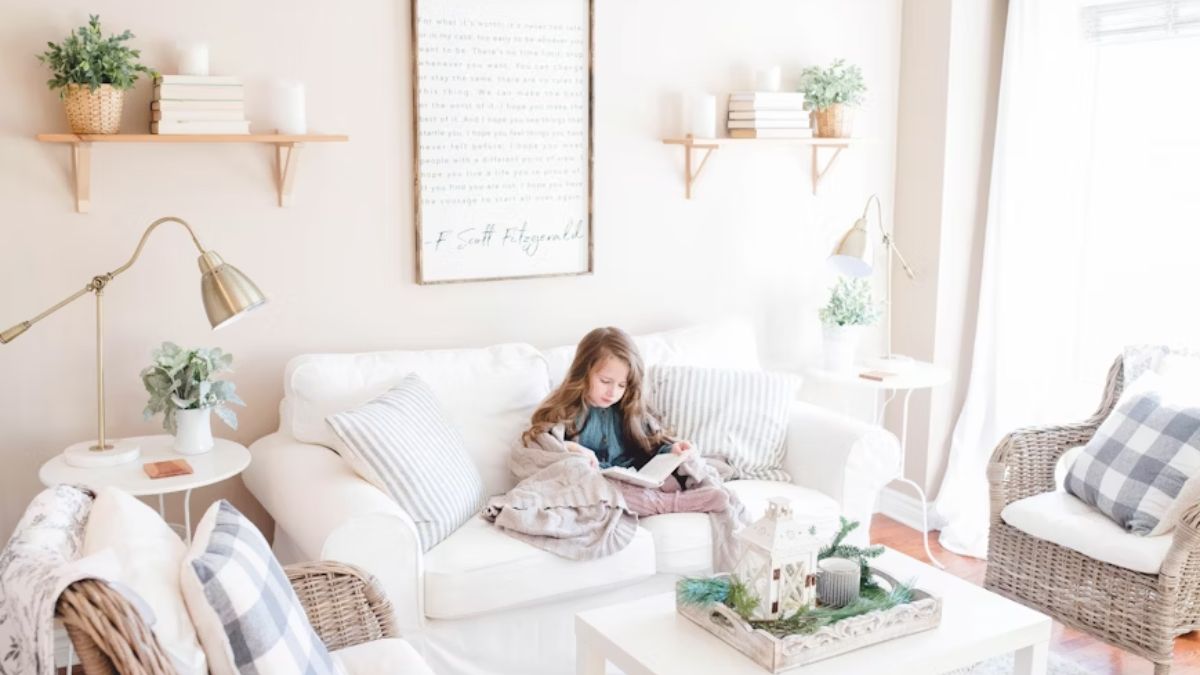 A young girl in a cozy pastel room with soft rose light, receiving ABA therapy instruction.