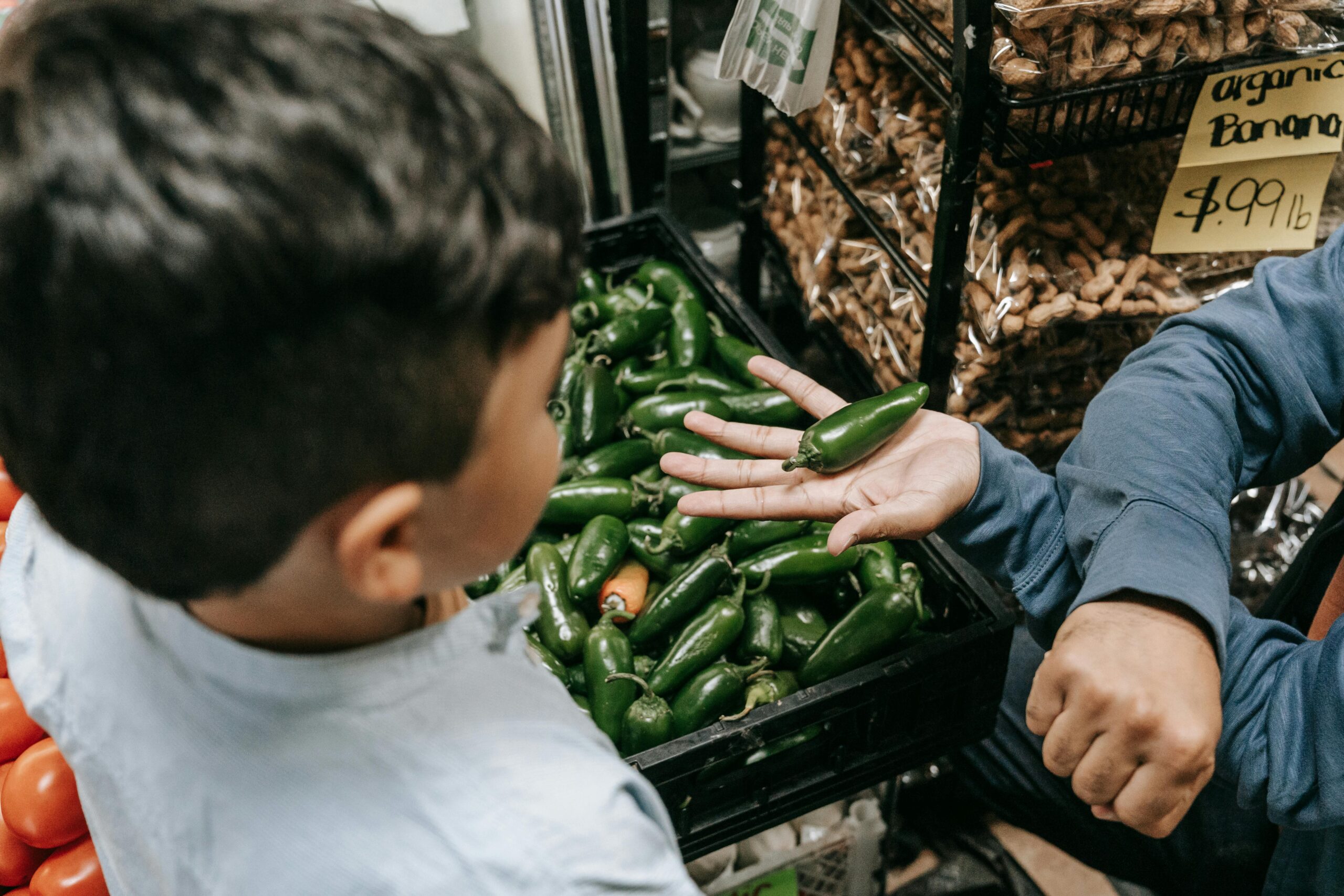 A young boy purchasing vegetables at a market.