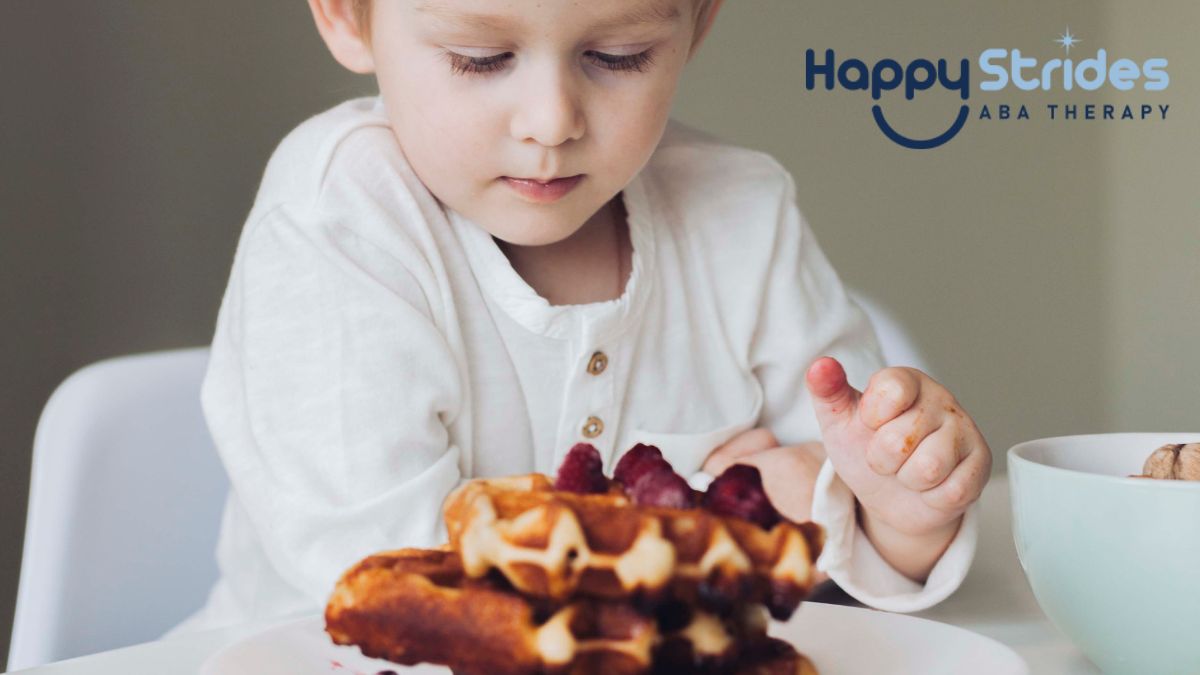 Autism and eating too much, a young boy looks down at a tall stack of waffles in front of him, ready to eat.