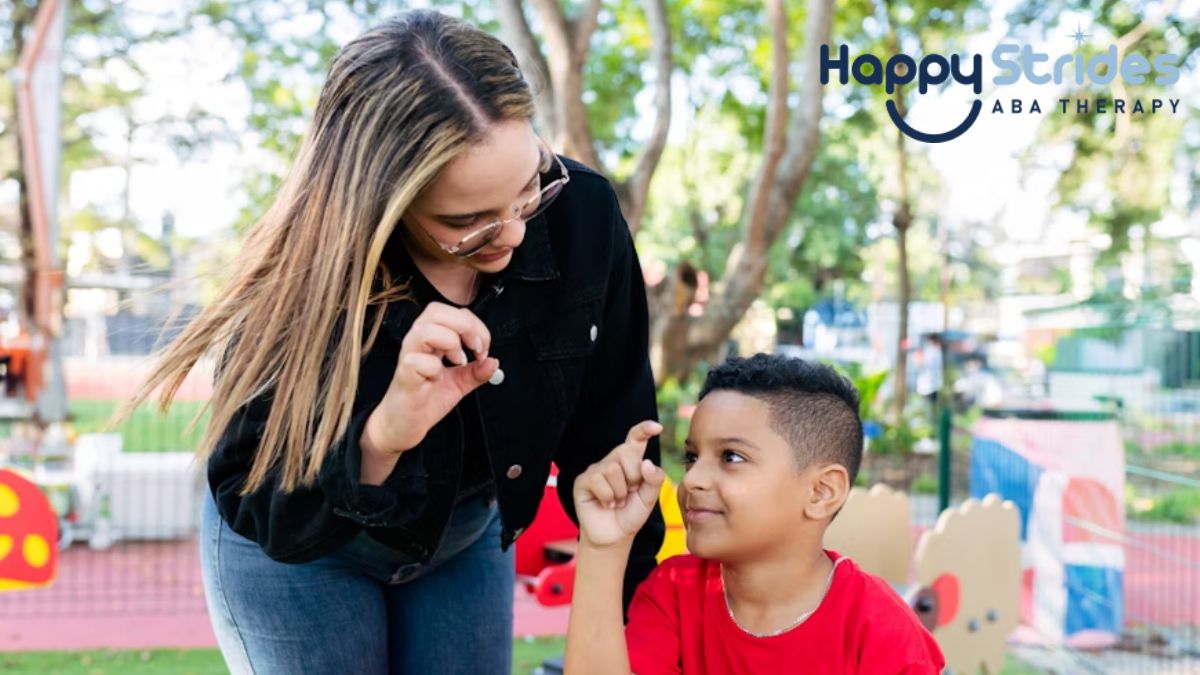 Can non-verbal autism be cured, a female teacher uses hand gestures to communicate with a young boy in the playground.