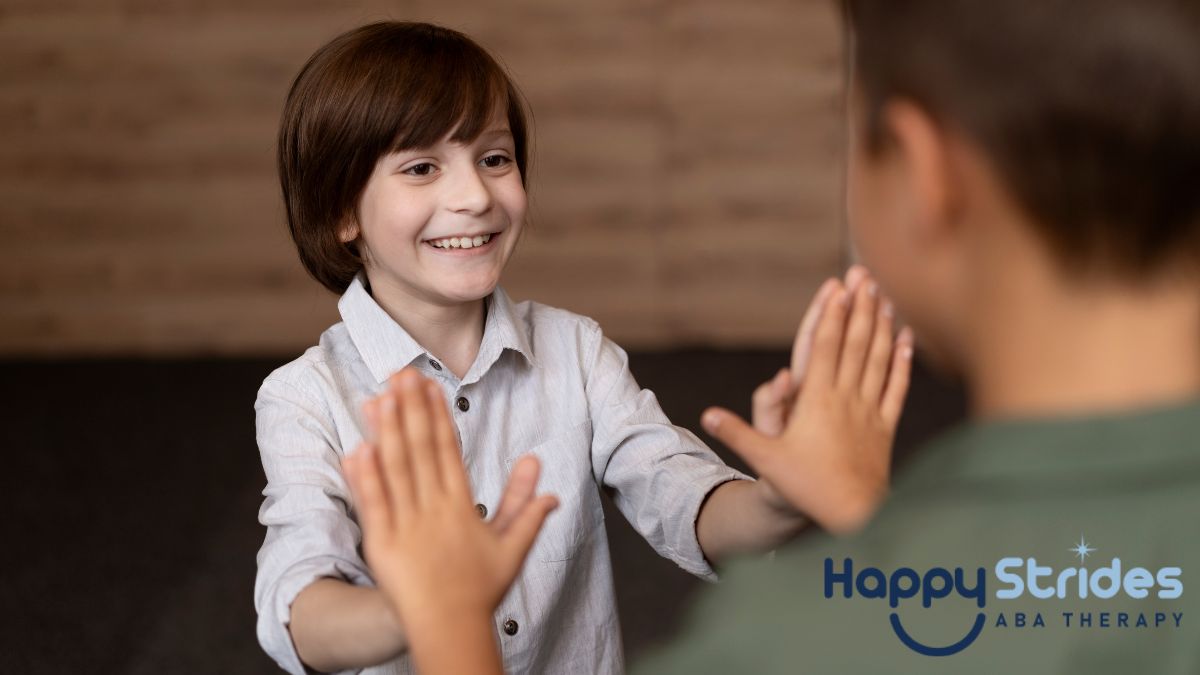 A child smiles while using hand gestures to communicate with an adult, illustrating nonverbal autism.