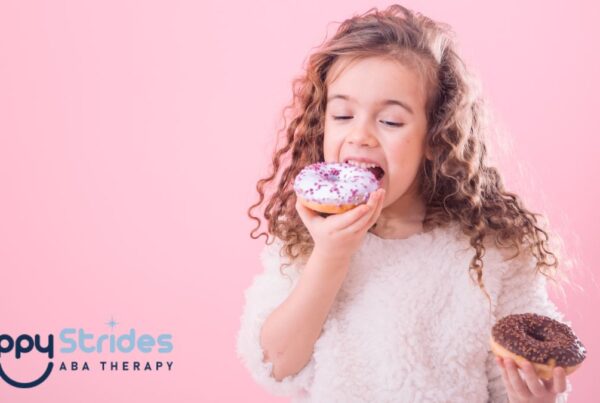 Autism and eating too much, a young child eats donuts voraciously while standing in a room with a pink background.