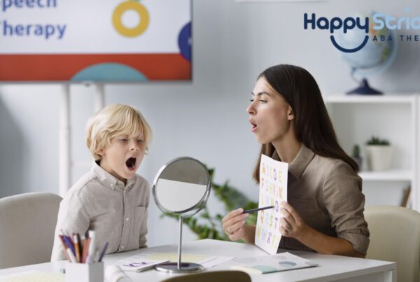 A female therapist guides a young boy in prompt therapy in a bright white room, illustrating autism support and intervention.