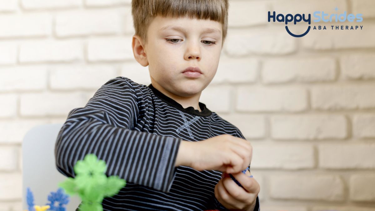A young boy with autism plays with flower-shaped plastic toy blocks, enjoying a moment of focus and attention.