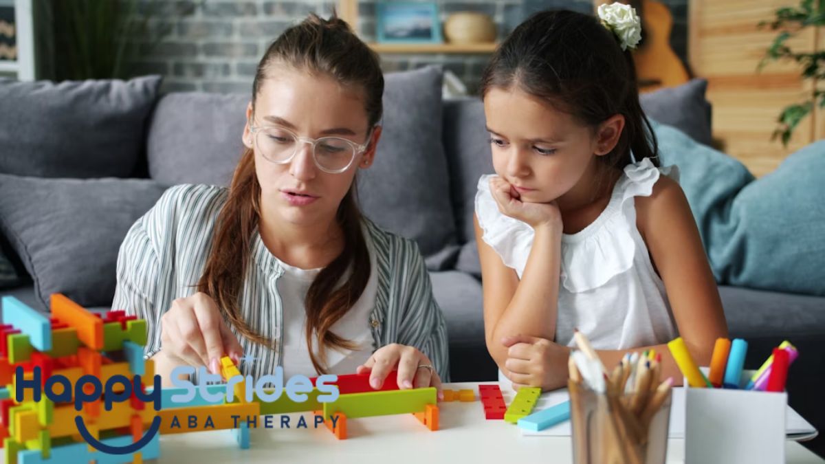 An adult guides a young child in a puzzle game on the coffee table during at-home autism therapy, while they sit on the living room floor.