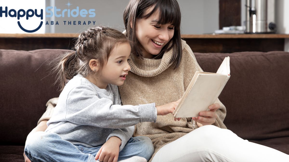A mother and her child sitting on a sofa, reading a book together and enjoying quality time, learning about ABA therapy.