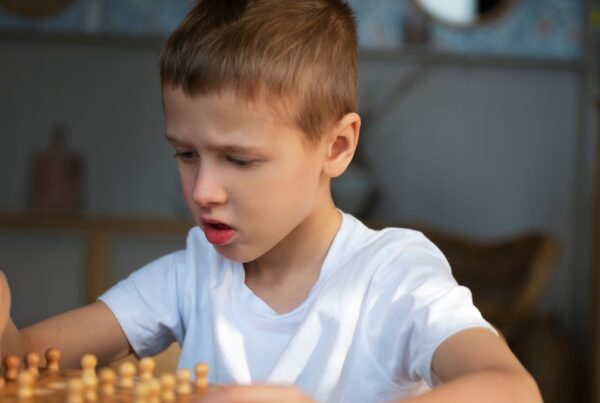 Boy completing a board game, illustrating problem-solving skills often supported in autism.