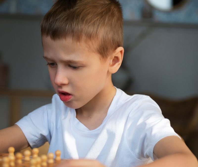 Boy completing a board game, illustrating problem-solving skills often supported in autism.