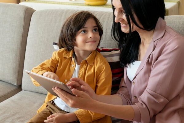 Boy receiving guidance from his parent while working on an activity, demonstrating learning and problem-solving.
