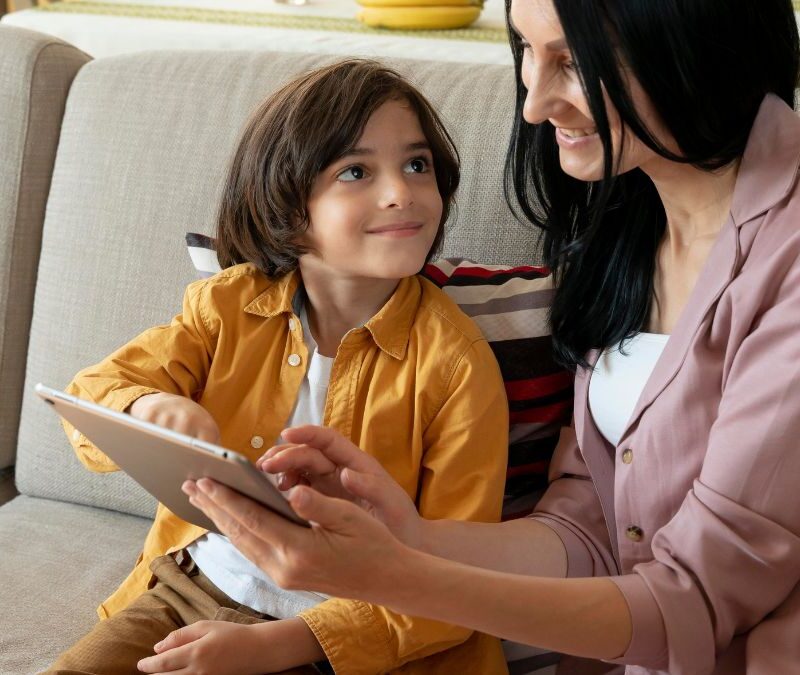 Boy receiving guidance from his parent while working on an activity, demonstrating learning and problem-solving.