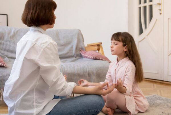 Young girl guided by her parent through a meditation activity, focusing on calm and preparation for transition.