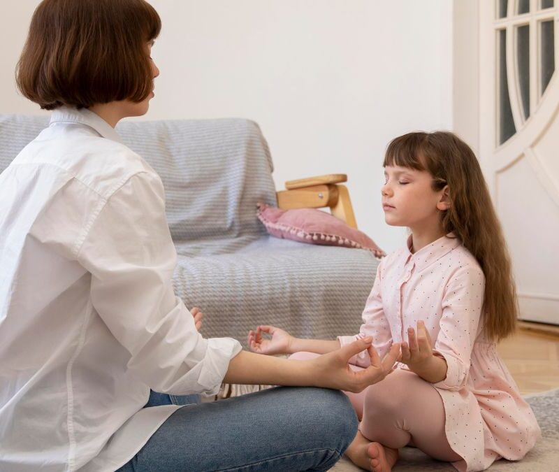 Young girl guided by her parent through a meditation activity, focusing on calm and preparation for transition.