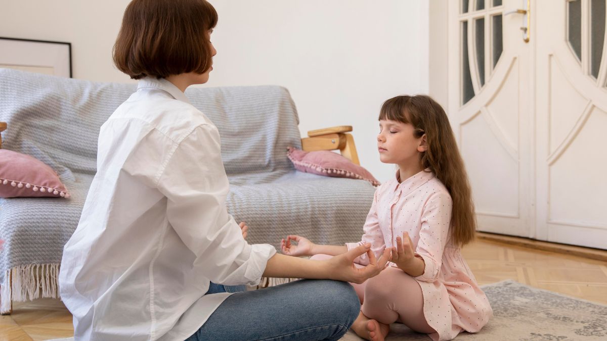 Young girl guided by her parent through a meditation activity, focusing on calm and preparation for transition.