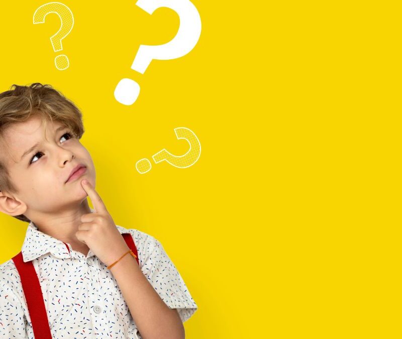 A boy with autism looks upward to the right with a wondering expression, while illustrated question marks appear above him to reflect his thoughts about executive functioning.
